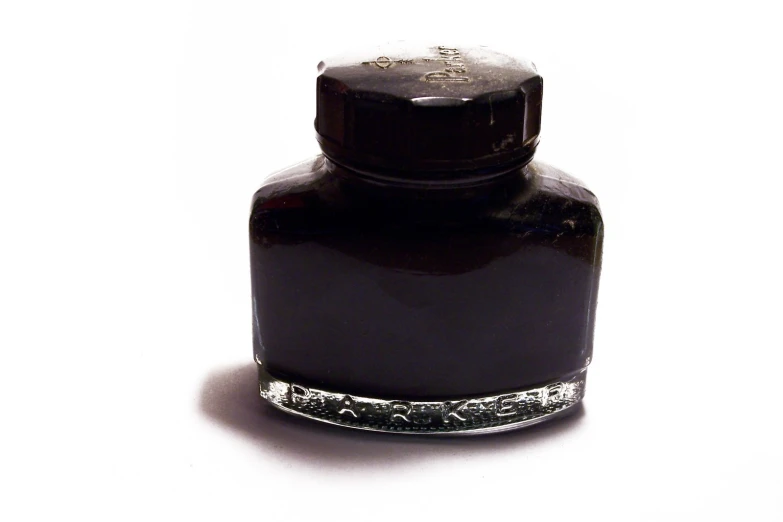 a bottle of ink is sitting on a white surface