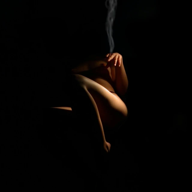 the image shows a woman's back as she smokes