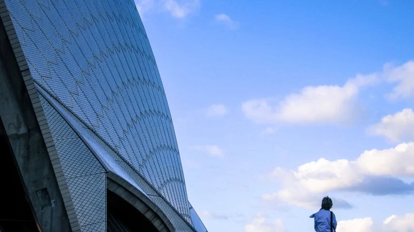 a young person is standing alone outside an architectural building