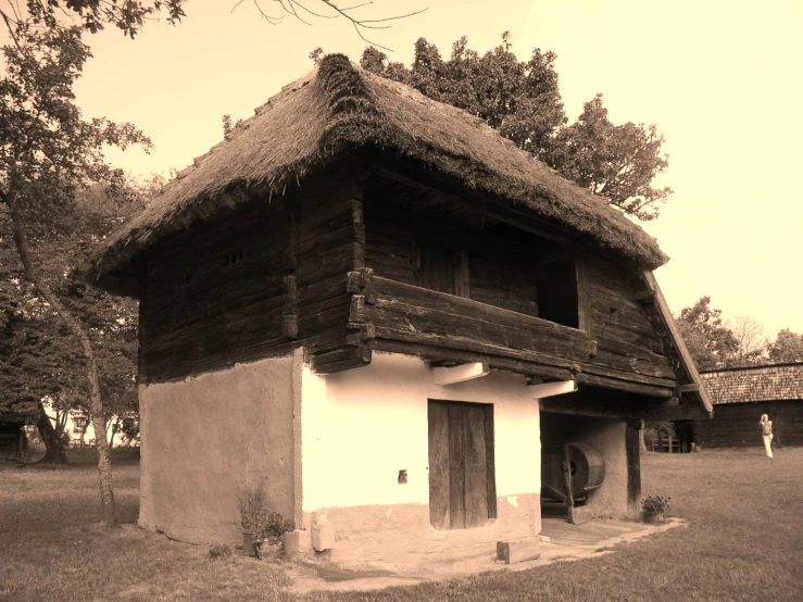 a very pretty old house with a big thatched roof