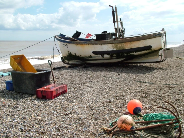 a beached boat and various containers sitting on the beach