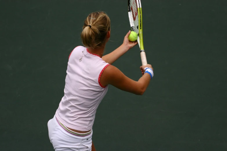 the young female tennis player is waiting to hit the ball