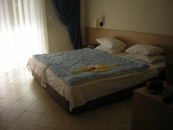 a bedroom with an extra bed and window blinds