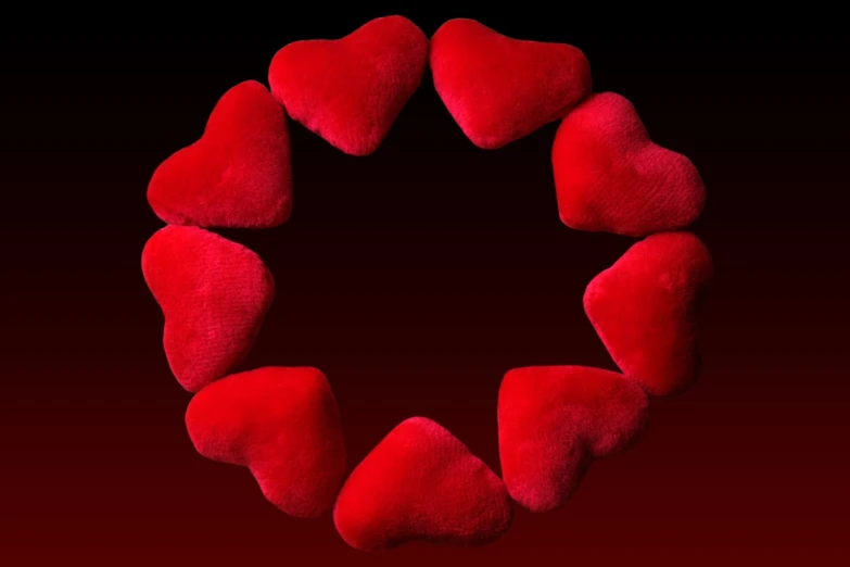 a red heart shaped pillow arranged in a circle