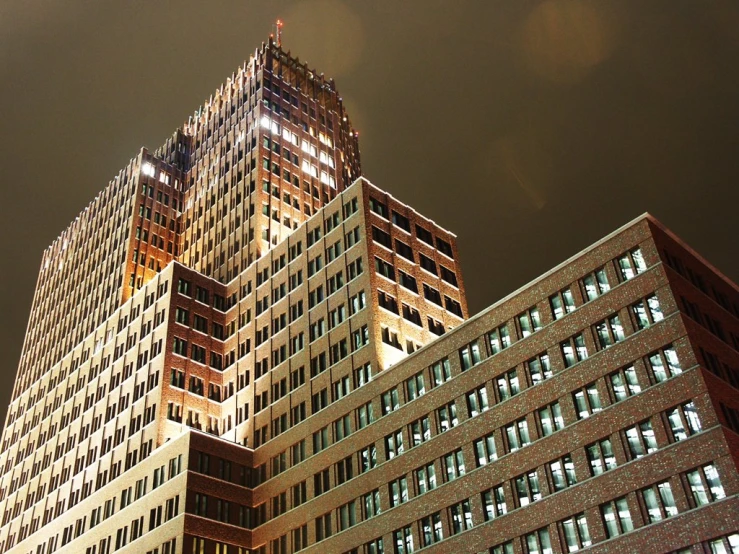 two large tall buildings sit in a dark night