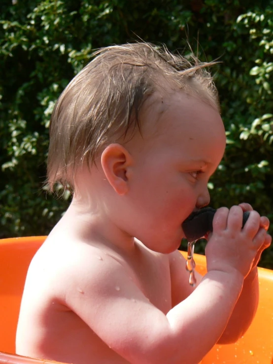 a baby boy is eating soing with a spoon