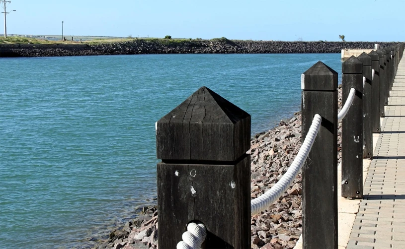 wooden dock with white rope around it near the water