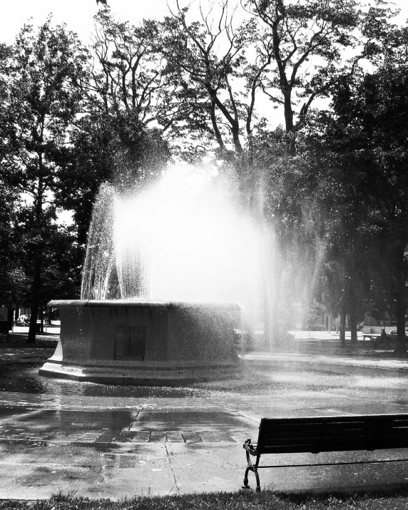 the sun shines behind a fountain as water spouts from the ground