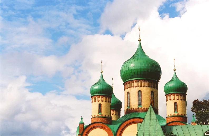 a large building has many tall green towers