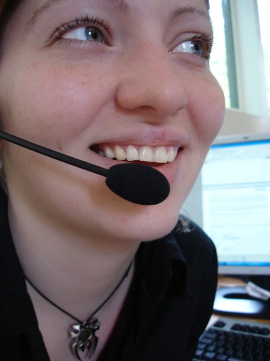 a smiling woman wearing a headset and a microphone