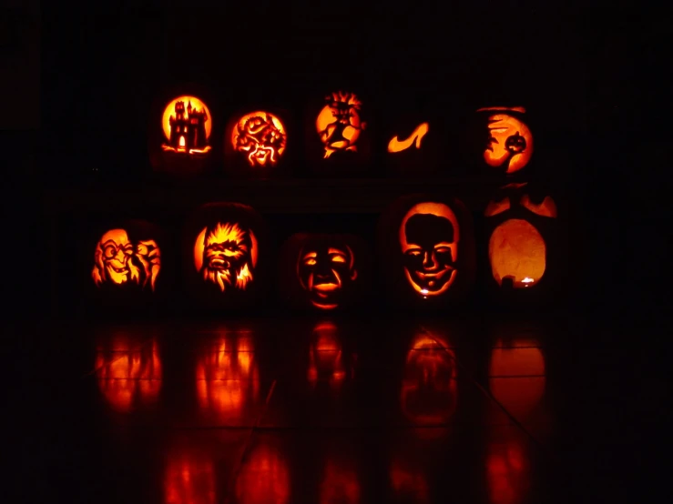 pumpkins sitting in a row carved to look like faces