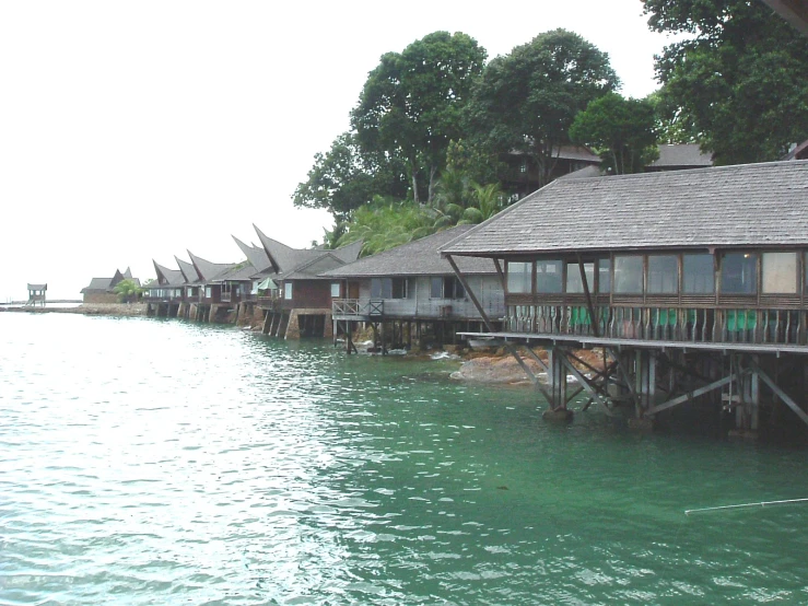 row of houses by a sea side water with houses on stilts
