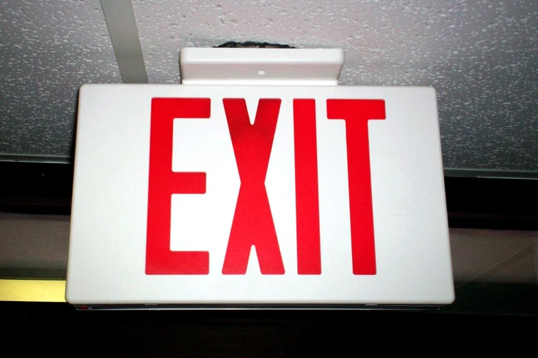 a red and white sign is hanging from the ceiling