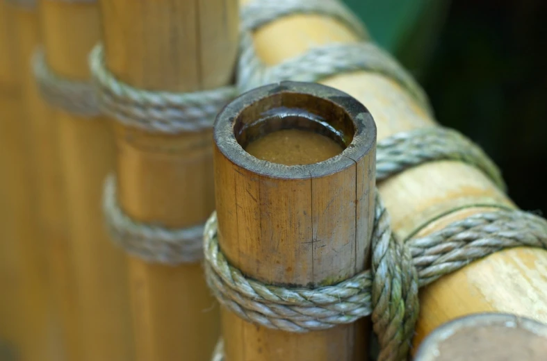 three wooden pipes with ropes wrapped around them