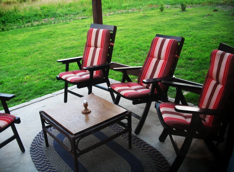 some chairs and a coffee table on a porch