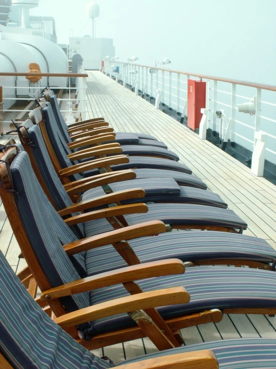 a row of chairs sitting on top of a wooden deck