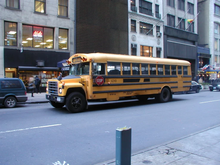 school bus parked in front of some tall buildings