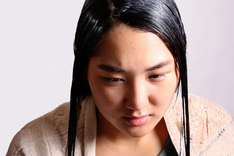 a young woman with black hair, looking down