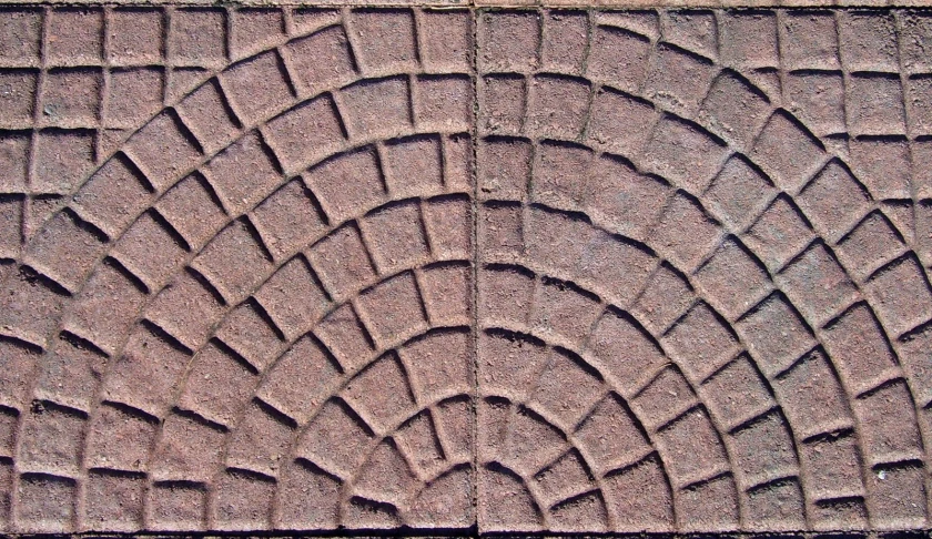 a red and brown brick surface has many small designs on it