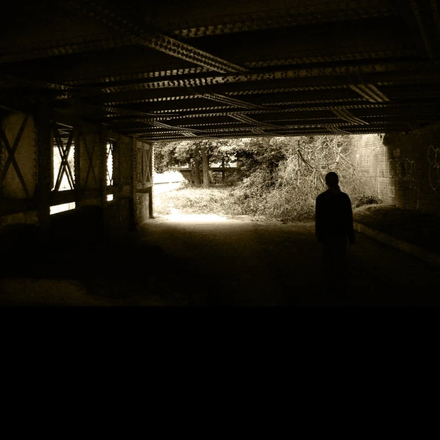 a man walking into a tunnel with a dark background