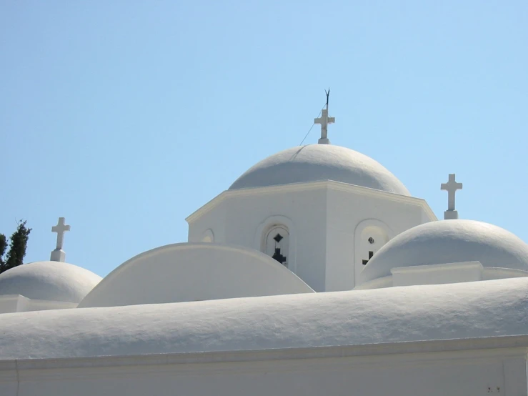 a church with white domes and crosses on the top