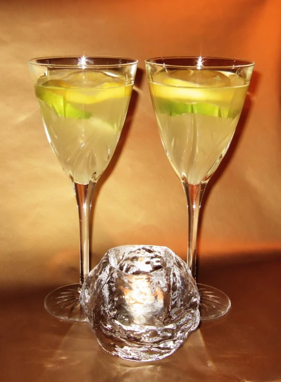 two goblets with yellow and green liquid are on a table