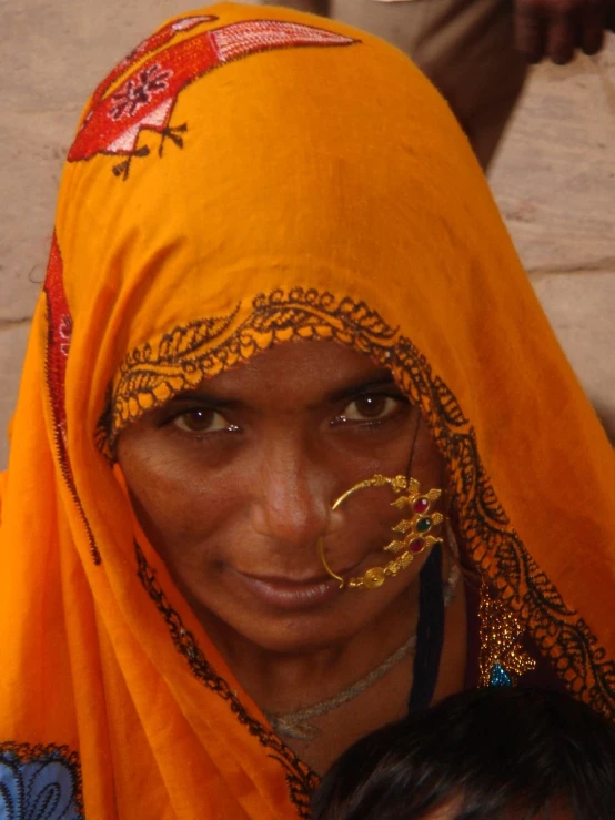 the woman is wearing a yellow headdress and a ring