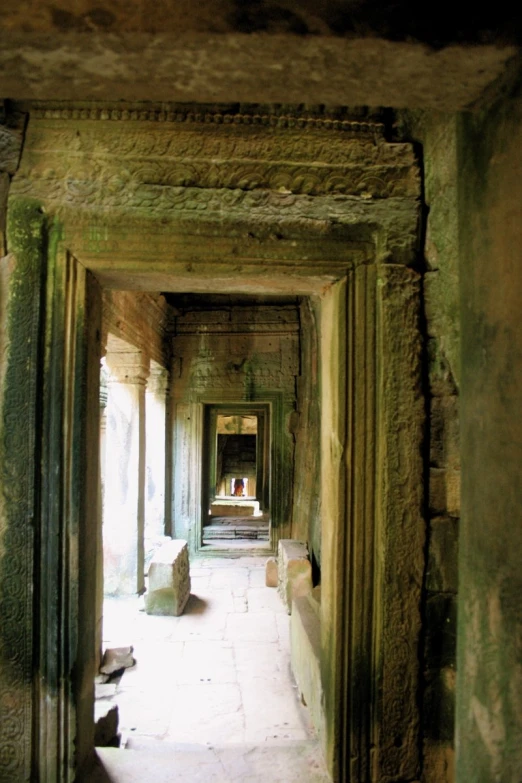 the entrance to a temple with stone pillars and benches