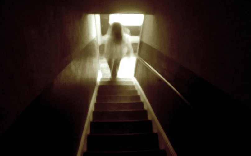 a person walking down some stairs in the dark