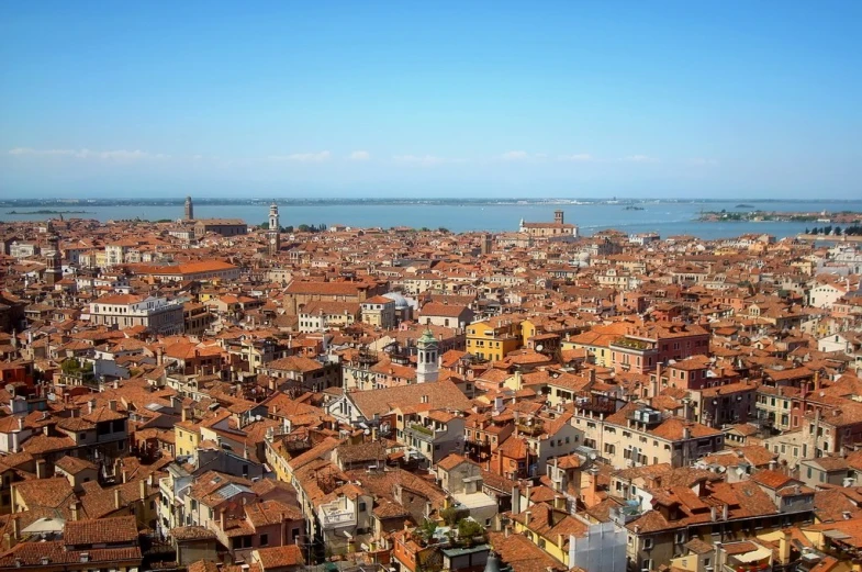 a large city with red roofed buildings and blue sky