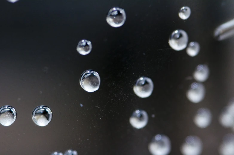 many water drops falling off the side of a window