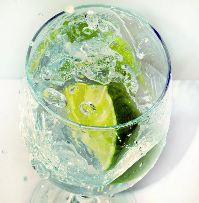 a lime slice sits in water and bubbles