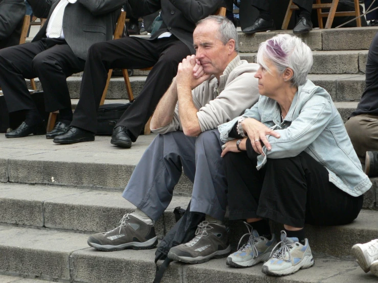 a man and woman sitting on steps beside each other