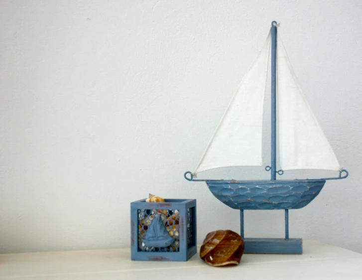 a small blue boat and some bread on a white shelf