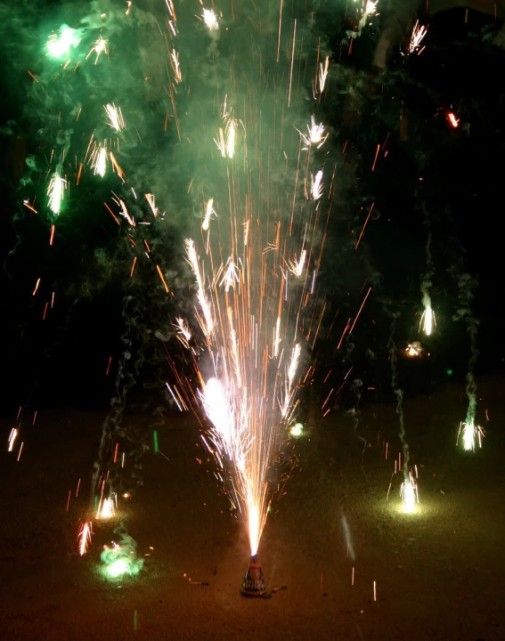 fireworks with green and purple light in dark night sky