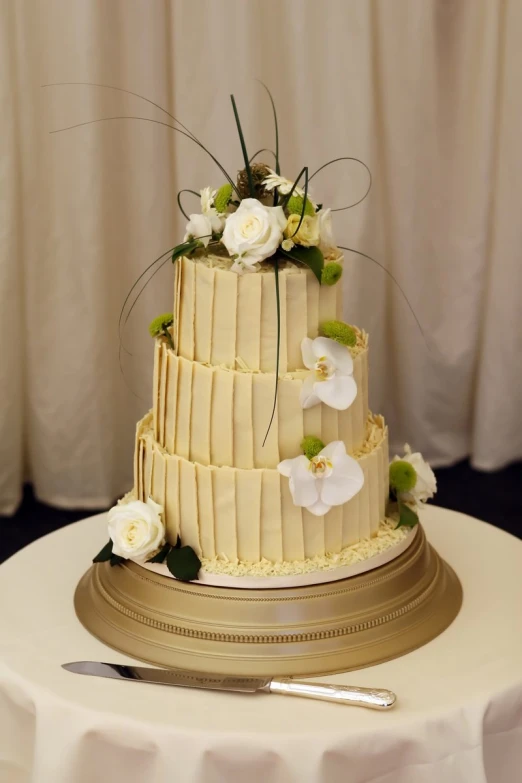 a three tiered cake with flowers on a plate