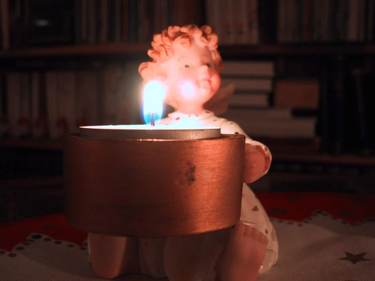 a candle is lit as a baby looks on