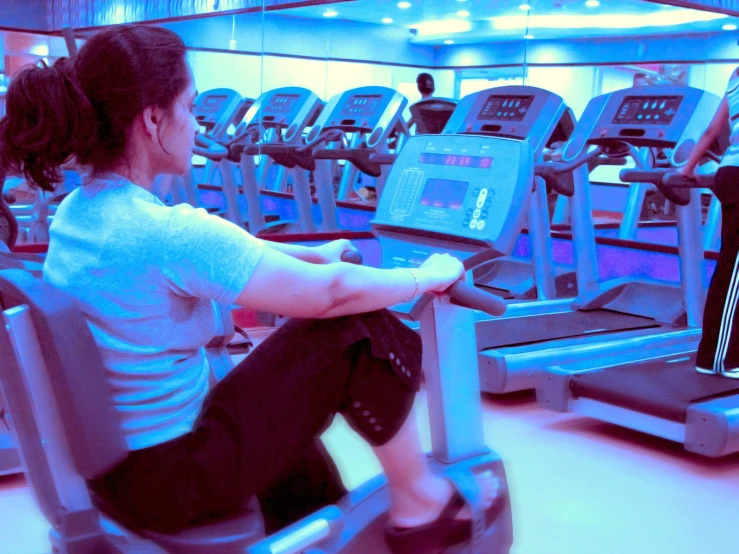 a girl is using the exercise machines in the gym