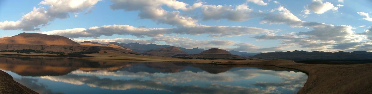 the mountain ranges are reflected in the calm lake