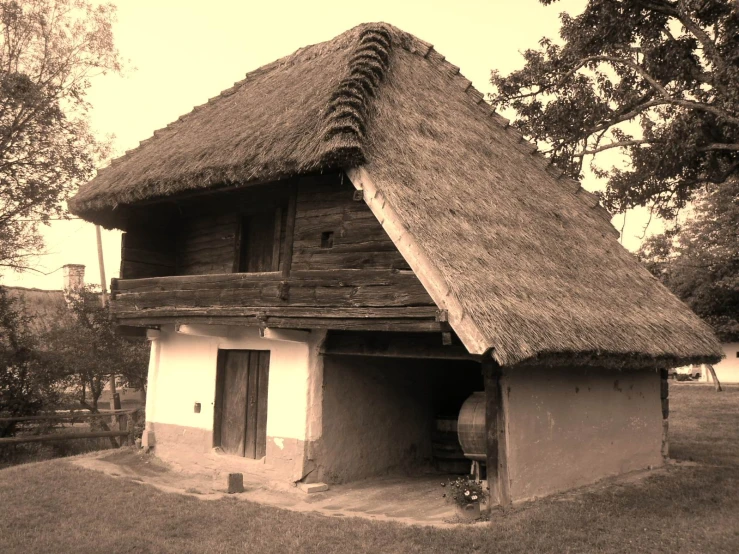 an old fashioned cabin house with a thatched roof