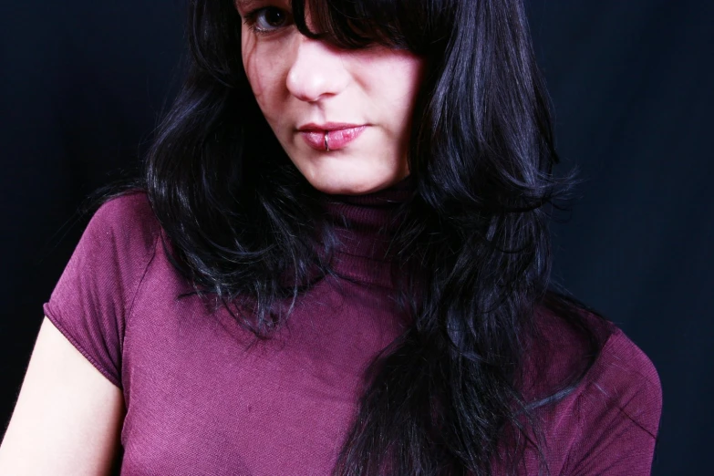 a woman is posing for a po with her long dark hair