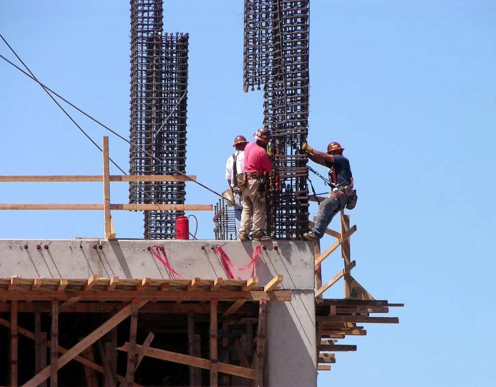 two men with helmets are on the top of the building