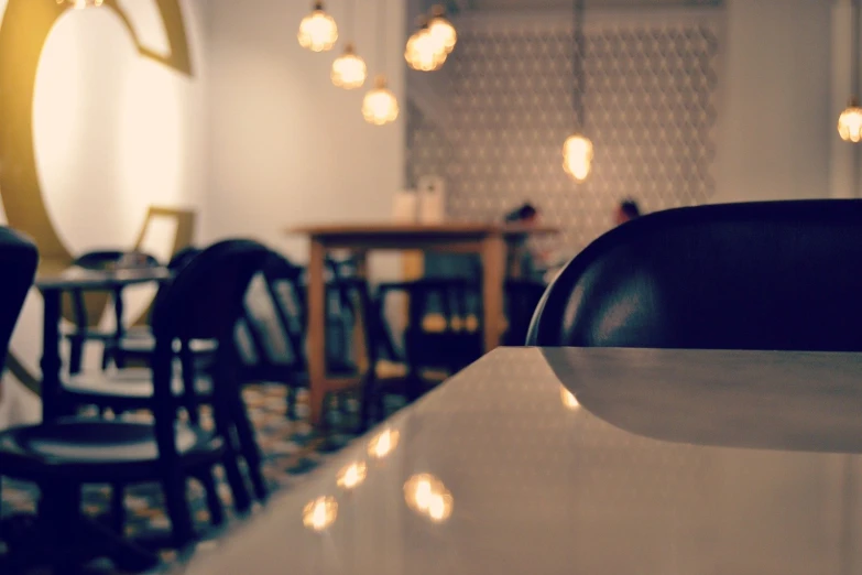 a dining table with chairs and a few lights hanging