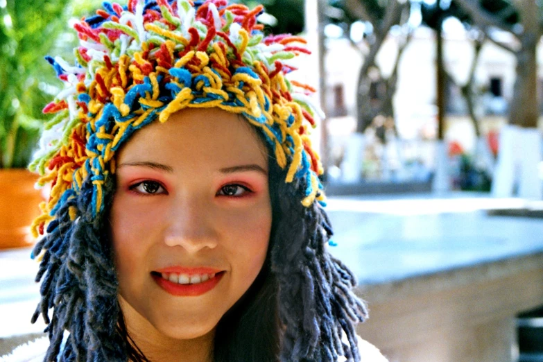 a woman wearing a colorful hat by the water