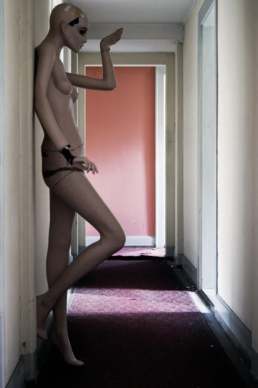 a woman in a bikini and thongs standing next to a hallway