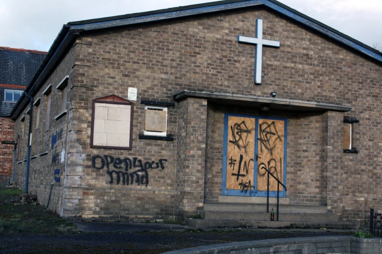 an old church with graffiti in front of it