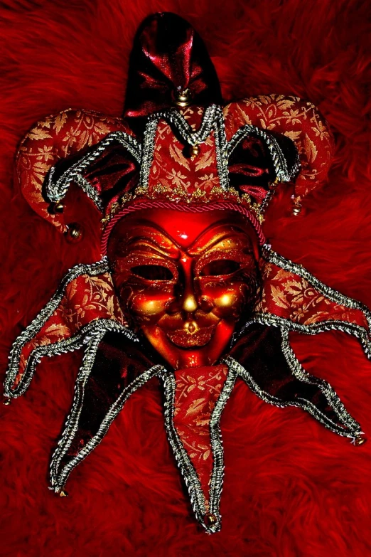 a red mask and chain are on top of a red rug