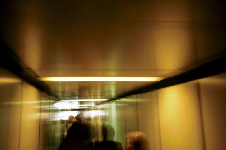 several people moving down a long hallway in an elevator