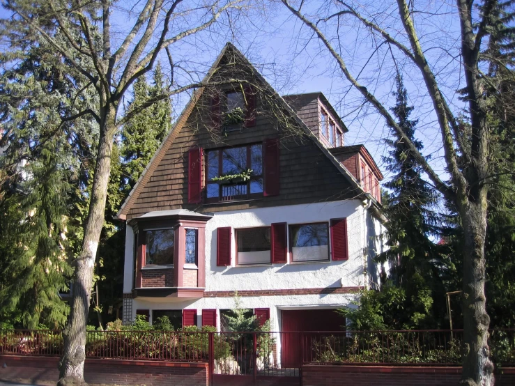 an old victorian style house with red shutters