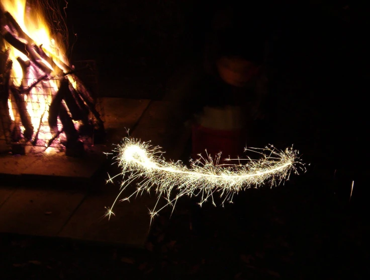 someone who is blowing sparklers in the night